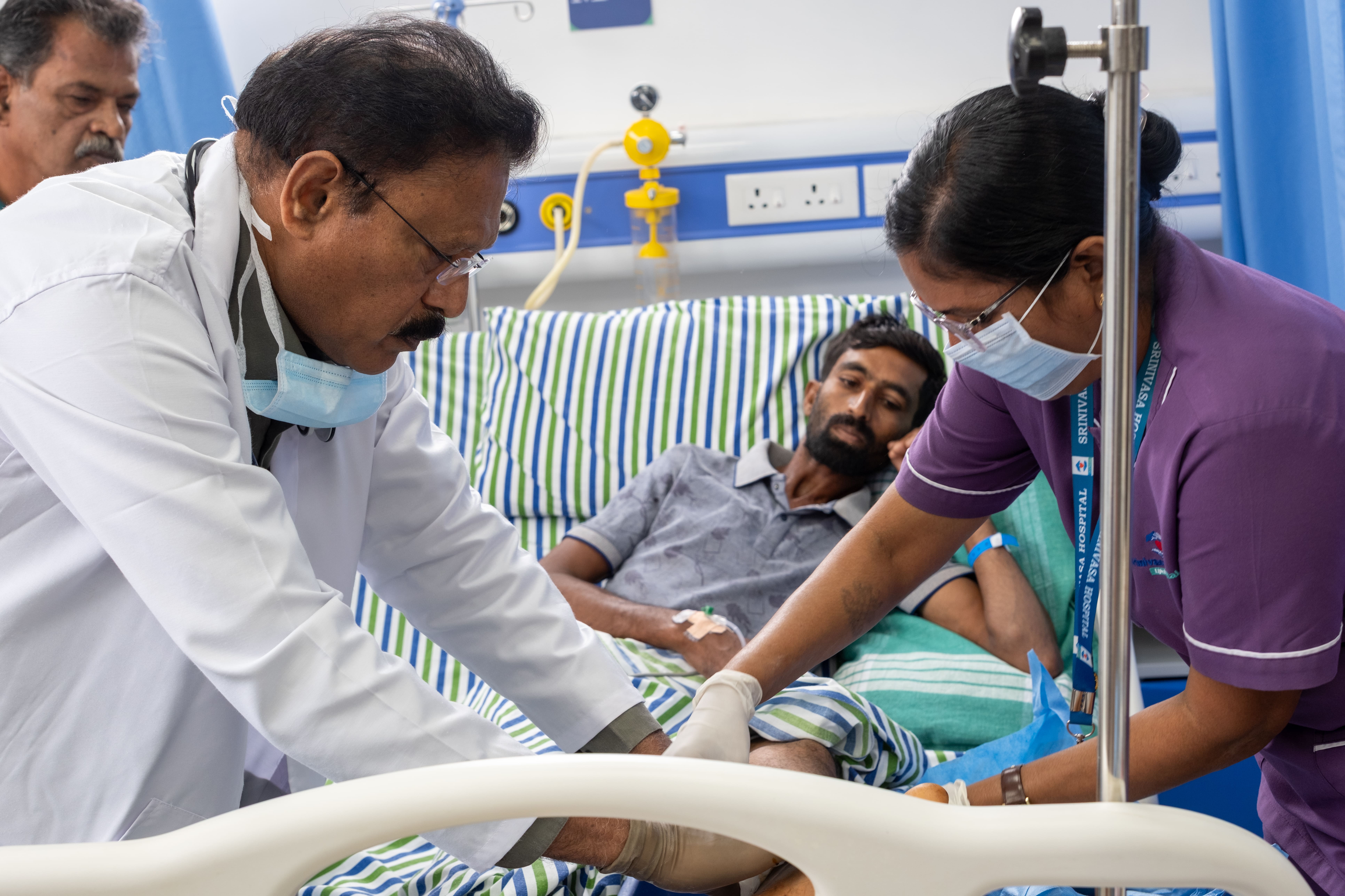 Dr. Nagaraj and nurse, Srinivasa Hospital, Bengaluru, Karnataka, India. Dr. Nagaraj and a nurse attend to an emergency snakebite patient in the hospital, highlighting the critical importance of timely medical care in managing venomous bites.
